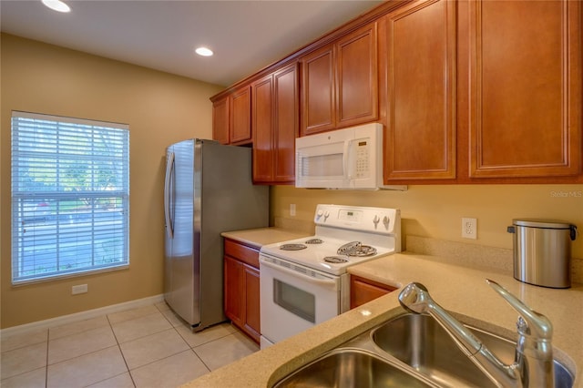 kitchen with white appliances, a sink, and light countertops