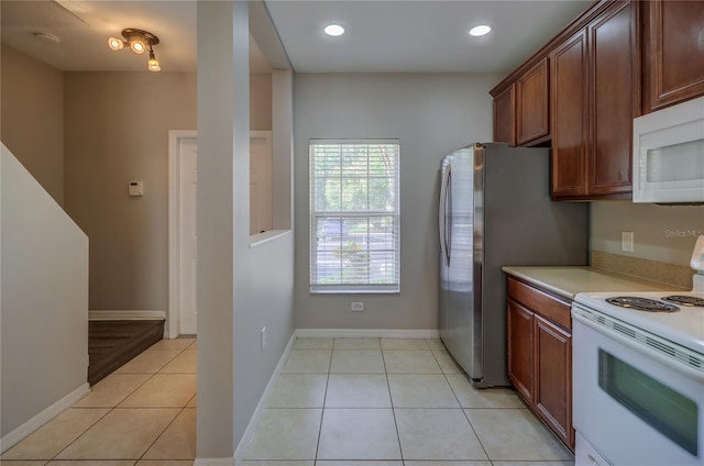 kitchen with light tile patterned flooring, white appliances, baseboards, recessed lighting, and light countertops
