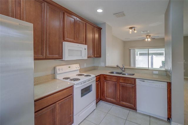 kitchen with light tile patterned flooring, a sink, white appliances, light countertops, and visible vents