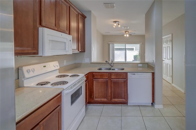 kitchen featuring a sink, white appliances, light countertops, light tile patterned floors, and visible vents
