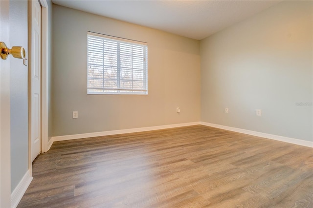 empty room featuring baseboards and wood finished floors