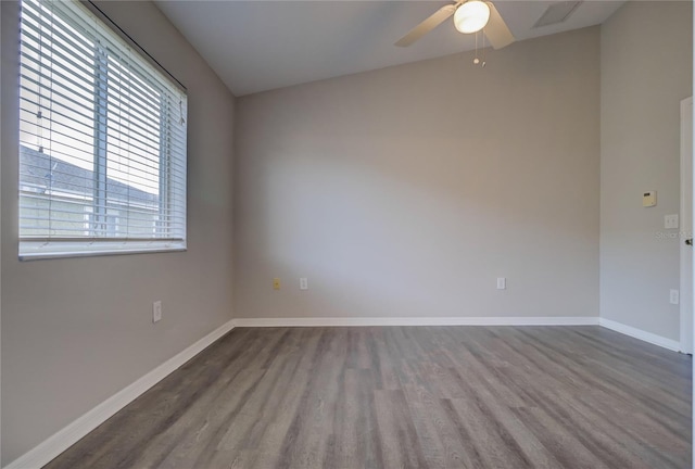unfurnished room featuring baseboards, ceiling fan, wood finished floors, and visible vents