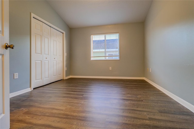unfurnished bedroom with baseboards, dark wood finished floors, and a closet