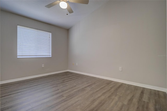 empty room with a ceiling fan, baseboards, and wood finished floors