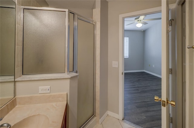 bathroom featuring vanity, baseboards, ceiling fan, and a stall shower