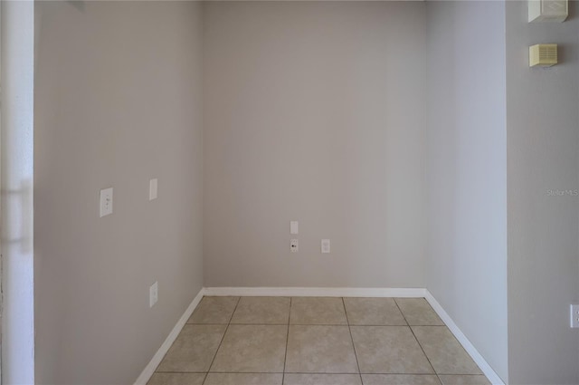 spare room featuring baseboards and light tile patterned flooring