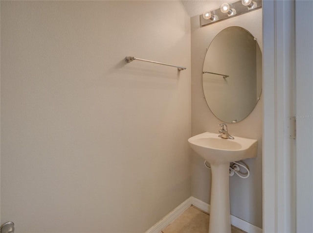 bathroom featuring baseboards, a sink, and tile patterned flooring