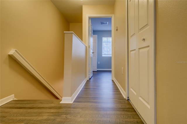 corridor with baseboards, dark wood finished floors, and visible vents