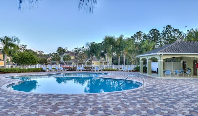 pool featuring fence and a patio area