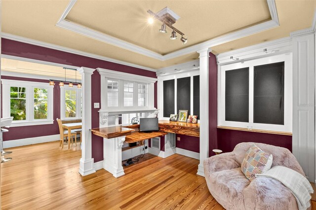 office with track lighting, ornamental molding, wood finished floors, ornate columns, and a raised ceiling
