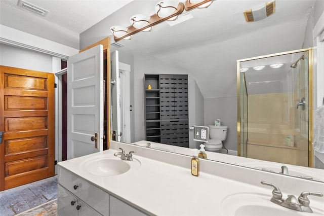 bathroom with visible vents, a closet, lofted ceiling, a sink, and a stall shower