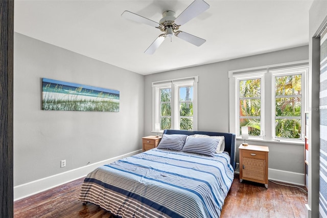 bedroom with a ceiling fan, baseboards, and wood finished floors
