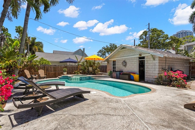 view of pool with an outdoor structure, a patio, a pool with connected hot tub, and a fenced backyard