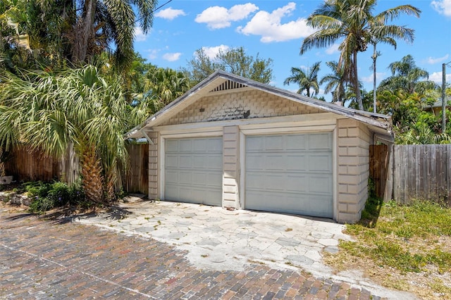 detached garage featuring fence