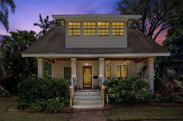 view of front facade with a porch and a shingled roof