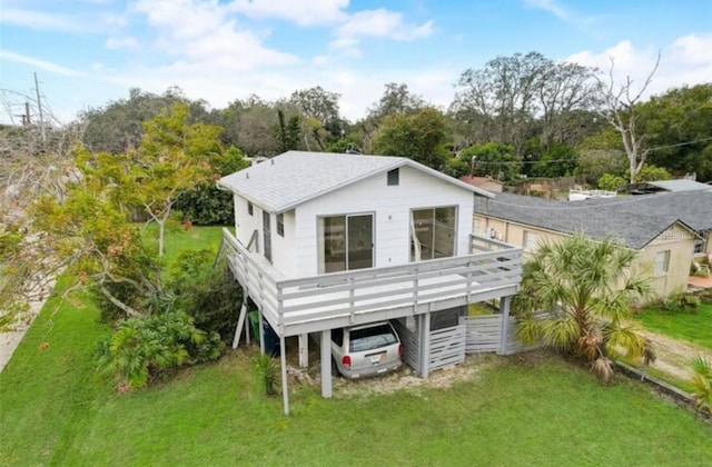 9706 N 22nd St, Tampa, FL 33612 - back of house with a carport, a lawn, a wooden deck, and view of scattered trees