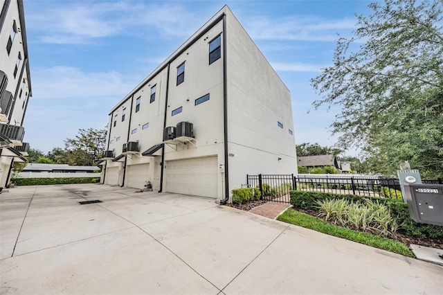 6904 S Macdill Ave Unit 1, Tampa, FL 33611 - view of home's exterior featuring fence, driveway, a garage, and stucco siding