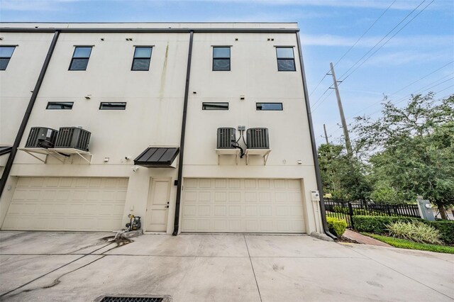 6904 S Macdill Ave Unit 1, Tampa, FL 33611 - view of front of property with a garage, stucco siding, concrete driveway, and fence