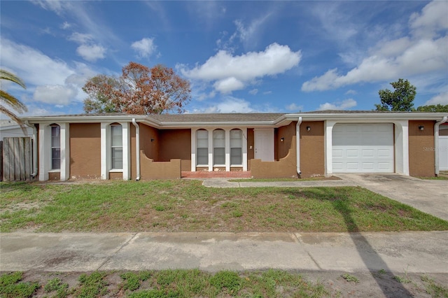 ranch-style house with a garage, stucco siding, driveway, and a front yard