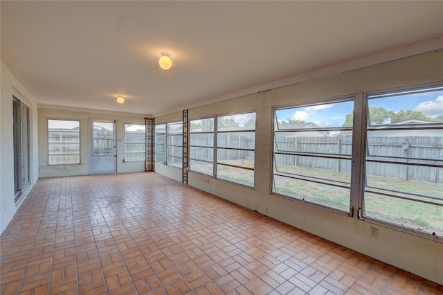 unfurnished sunroom with brick patterned floor