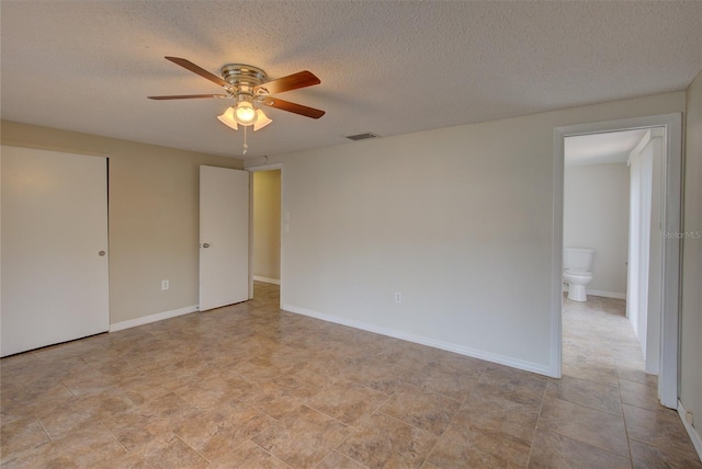 interior space with a ceiling fan, a textured ceiling, and visible vents