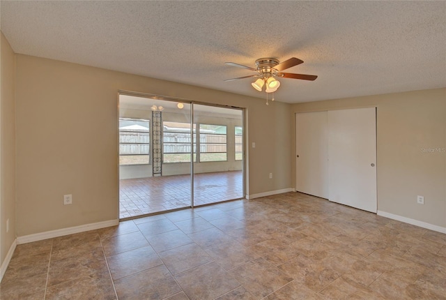 spare room featuring baseboards, a textured ceiling, and ceiling fan