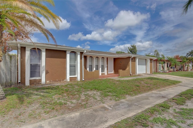 ranch-style home featuring a garage, stucco siding, driveway, and a front lawn