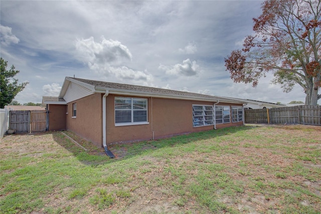 view of home's exterior with a lawn, a fenced backyard, and stucco siding
