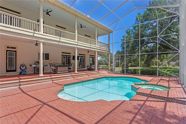 view of swimming pool with a patio, a ceiling fan, a lanai, and a pool with connected hot tub