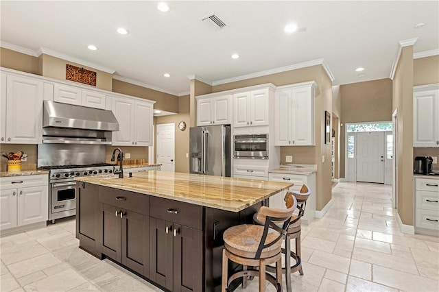 kitchen with under cabinet range hood, recessed lighting, white cabinets, and appliances with stainless steel finishes
