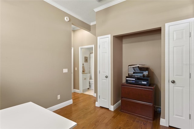 unfurnished bedroom with crown molding, baseboards, ensuite bath, and wood finished floors