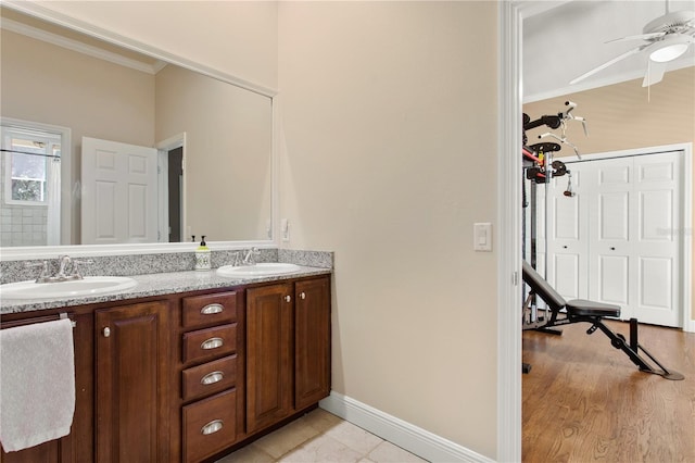 bathroom featuring double vanity, ceiling fan, ornamental molding, and a sink
