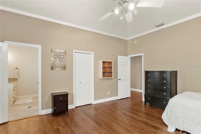bedroom with visible vents, baseboards, crown molding, and wood finished floors