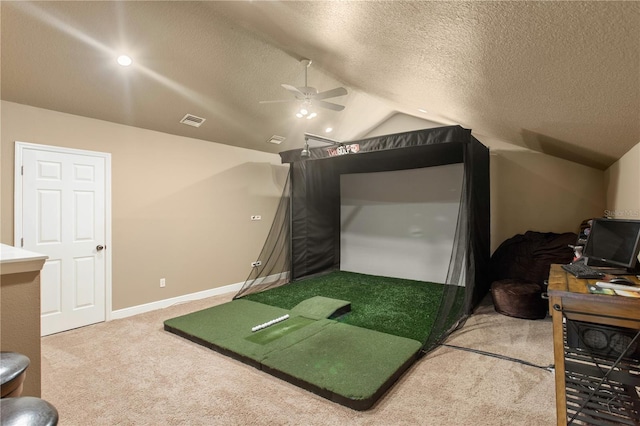 interior space featuring a ceiling fan, visible vents, vaulted ceiling, golf simulator, and carpet
