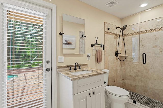 bathroom featuring vanity, toilet, visible vents, and a stall shower