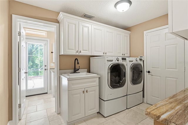 laundry area featuring washer and dryer, visible vents, a sink, and cabinet space