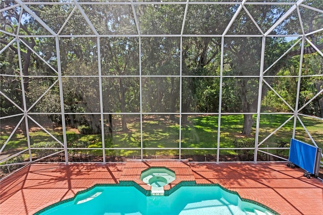 view of swimming pool with glass enclosure, a patio area, and a pool with connected hot tub