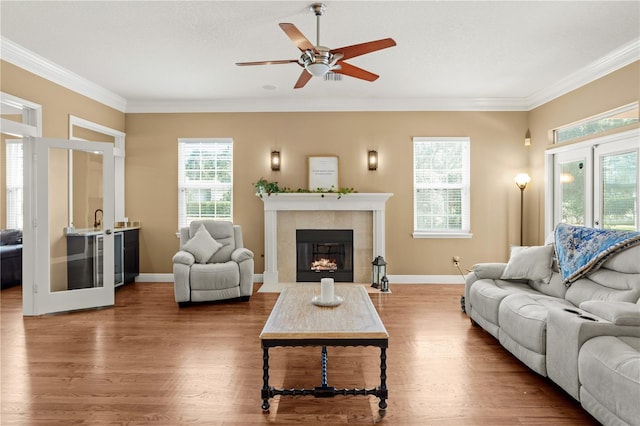 living room with a ceiling fan, wood finished floors, and ornamental molding