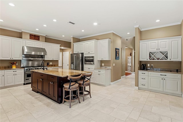 kitchen featuring recessed lighting, under cabinet range hood, high end appliances, and white cabinets