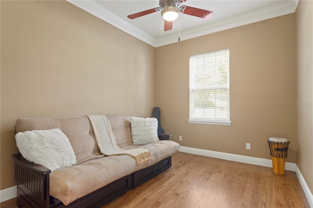 sitting room with crown molding, a ceiling fan, and baseboards