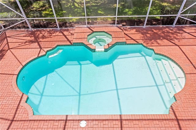 outdoor pool featuring an in ground hot tub, a lanai, and a patio area