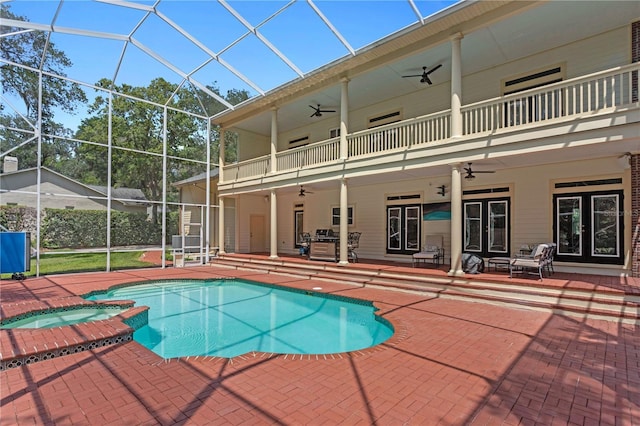 view of swimming pool featuring ceiling fan, a patio, french doors, a lanai, and a pool with connected hot tub