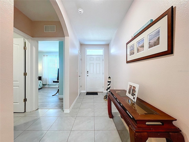 3205 Royal Tern Dr, Winter Haven, FL 33881 - entrance foyer featuring arched walkways, baseboards, light tile patterned flooring, and visible vents