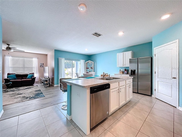 3205 Royal Tern Dr, Winter Haven, FL 33881 - kitchen featuring visible vents, open floor plan, a center island with sink, a sink, and appliances with stainless steel finishes