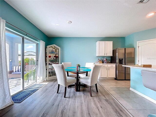 3205 Royal Tern Dr, Winter Haven, FL 33881 - dining space featuring light wood-style floors, baseboards, and a textured ceiling