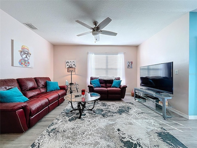 3205 Royal Tern Dr, Winter Haven, FL 33881 - living area featuring a ceiling fan, a textured ceiling, visible vents, and light wood-style flooring