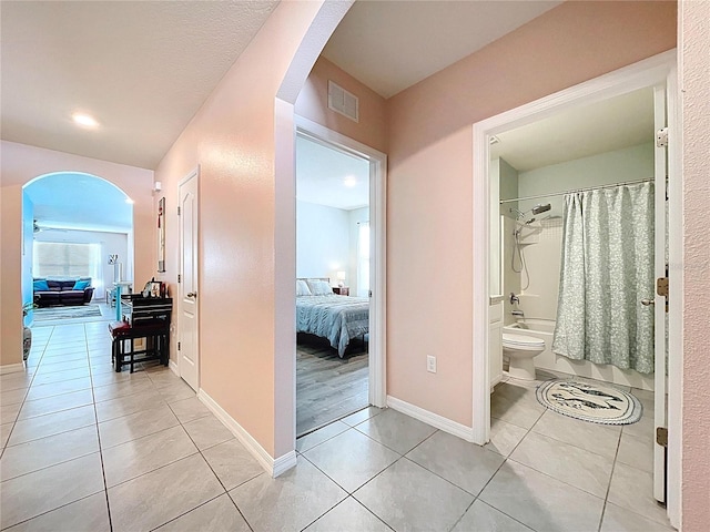 3205 Royal Tern Dr, Winter Haven, FL 33881 - hallway with light tile patterned floors, arched walkways, baseboards, and visible vents