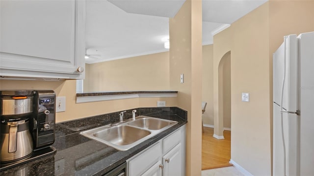501 Knights Run Ave Unit 1335, Tampa, FL 33602 - kitchen with freestanding refrigerator, arched walkways, a sink, white cabinetry, and ornamental molding