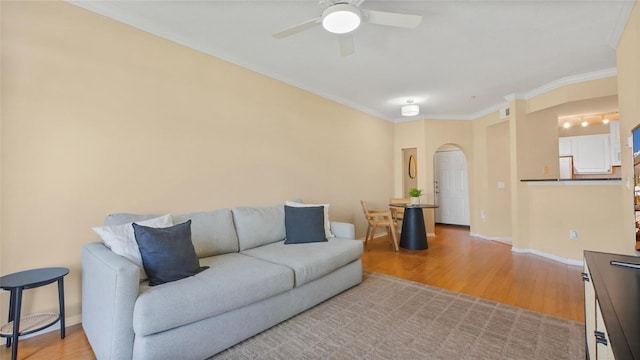 501 Knights Run Ave Unit 1335, Tampa, FL 33602 - living room with arched walkways, ceiling fan, light wood-style flooring, ornamental molding, and baseboards