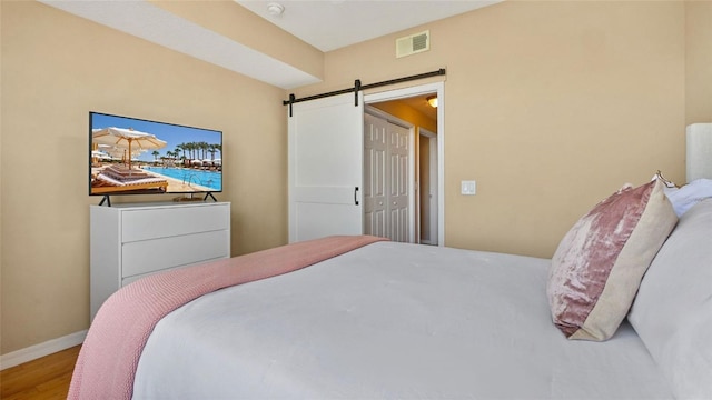 501 Knights Run Ave Unit 1335, Tampa, FL 33602 - bedroom featuring a barn door, wood finished floors, and baseboards